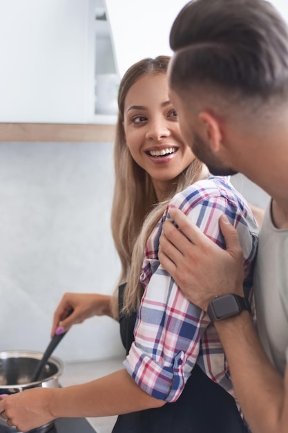 Joven bromeando con su esposa en la cocina