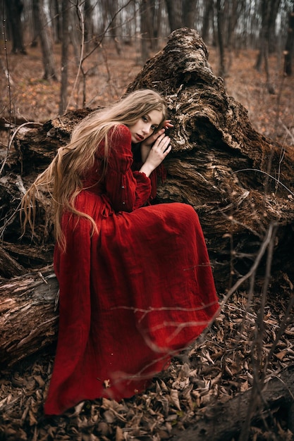 Joven bruja en el bosque de otoño