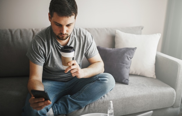 Joven con un café y con smartphone