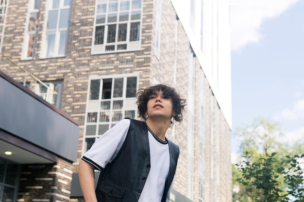 Foto joven en la calle contra el telón de fondo de los edificios de la ciudad