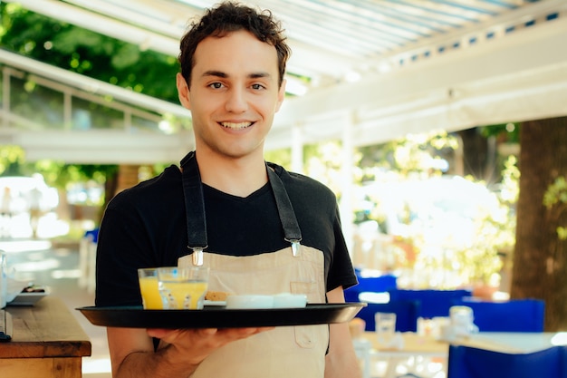 Joven camarero con bandeja.