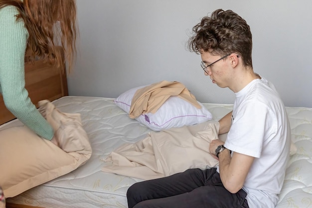 Foto un joven cambia la ropa de cama en la cama.