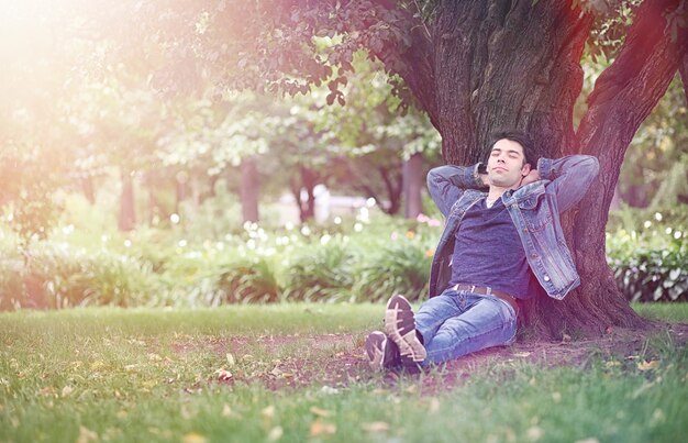 Un joven camina por el parque a la hora del almuerzo. Un hombre está paseando por la ciudad. Un estudiante en el parque.