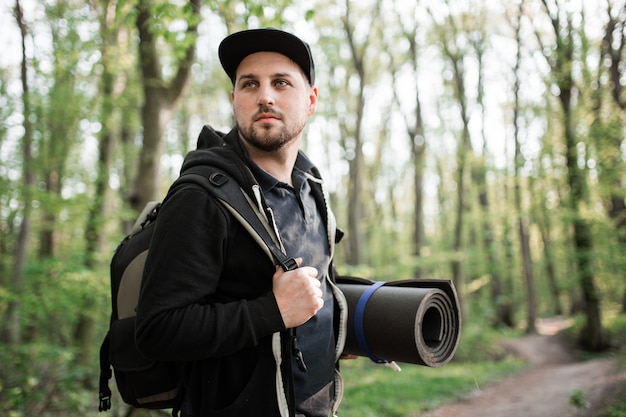 Joven caminando en bosque con mochila