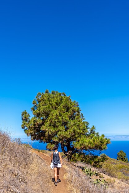 Una joven caminando por el camino de Las Tricias en la localidad de Garafia, en el norte de la isla de La Palma, Islas Canarias