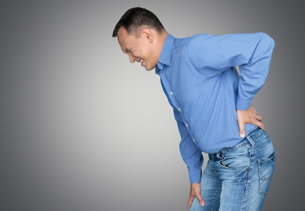 Joven con camisa azul con dolor en la espalda