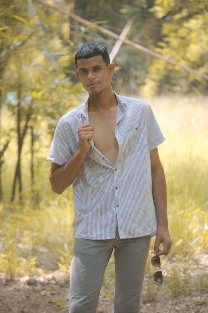 Un joven con camisa disfruta de la naturaleza.