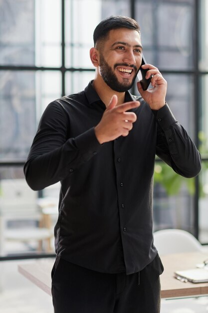 Joven con una camisa negra hablando por teléfono