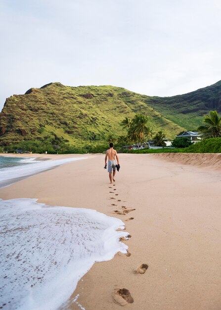 Joven sin camisa en la playa con equipo de buceo