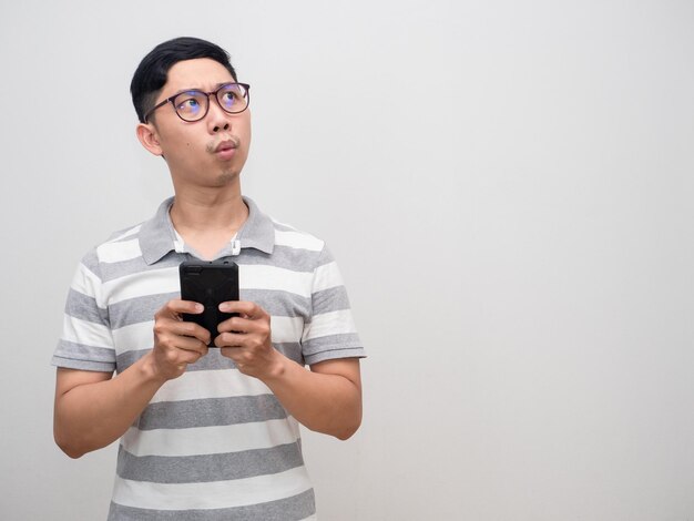 Joven camisa a rayas con gafas sostiene el teléfono inteligente se siente emocionado mirando el espacio de la copia