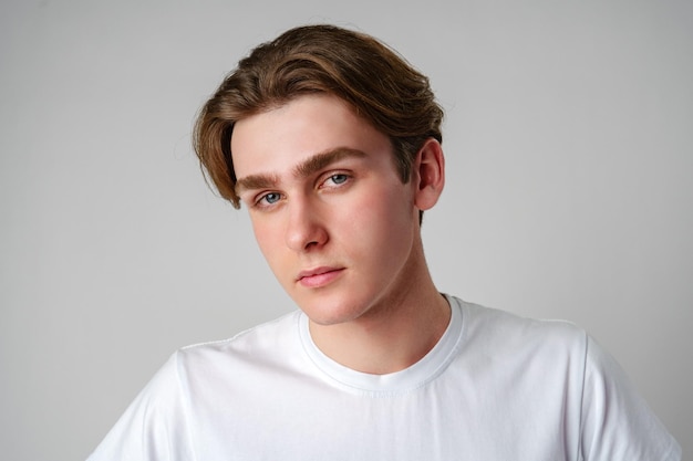 Un joven con una camiseta blanca mirando a la cámara