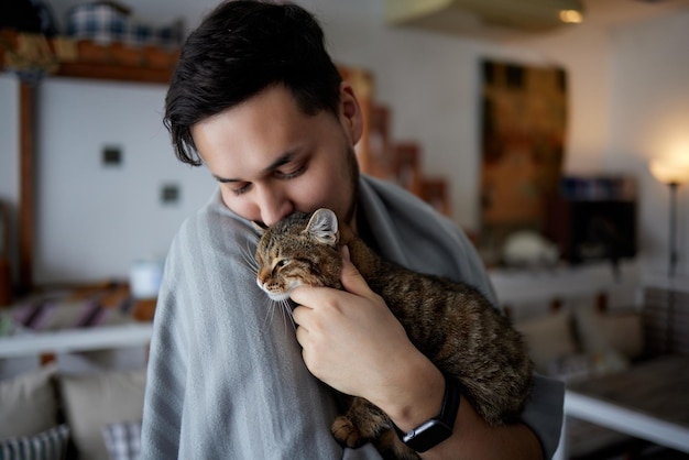 Joven con camiseta sosteniendo un gato.