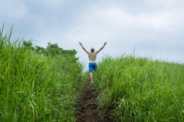 Joven en el campo levantando las manos