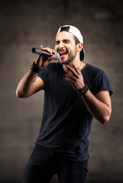 Foto joven cantando en un micrófono