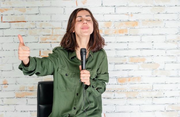 Foto joven cantante cantando y gesticulando pulgar arriba