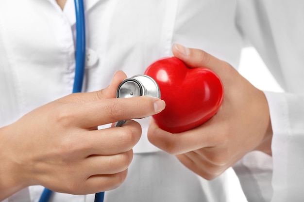 Una joven cardióloga sostiene un corazón de plástico de cerca