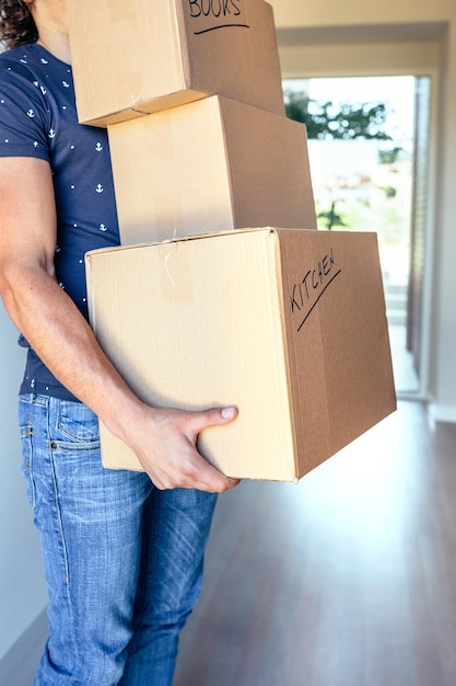 Joven cargando cajas de cartón en movimiento