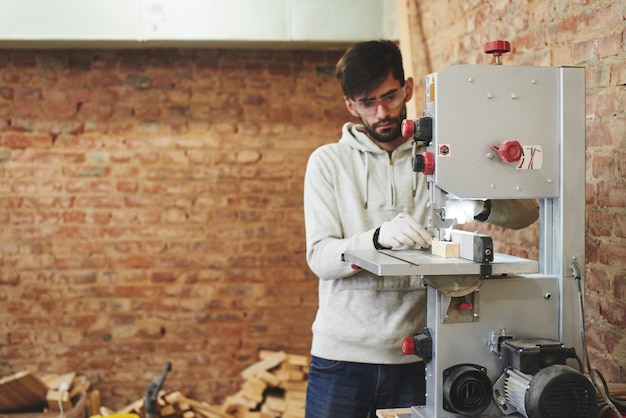 El joven carpintero trabaja en un taller.