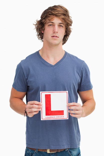 Joven con un cartel de conductor principiante