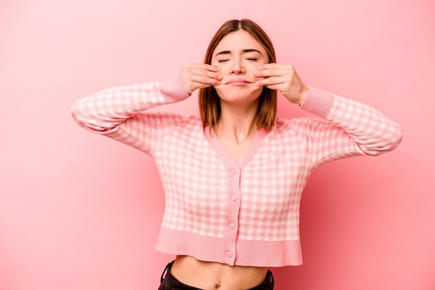 Joven caucásica aislada de fondo rosa dudando entre dos opciones