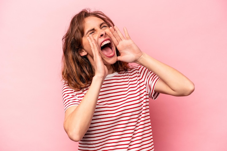 Foto joven caucásica aislada de fondo rosa gritando emocionada al frente
