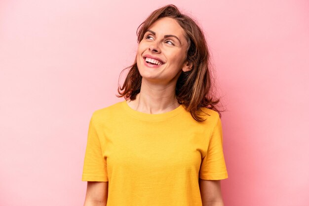 Joven caucásica aislada de fondo rosa relajada y feliz riendo el cuello estirado mostrando los dientes