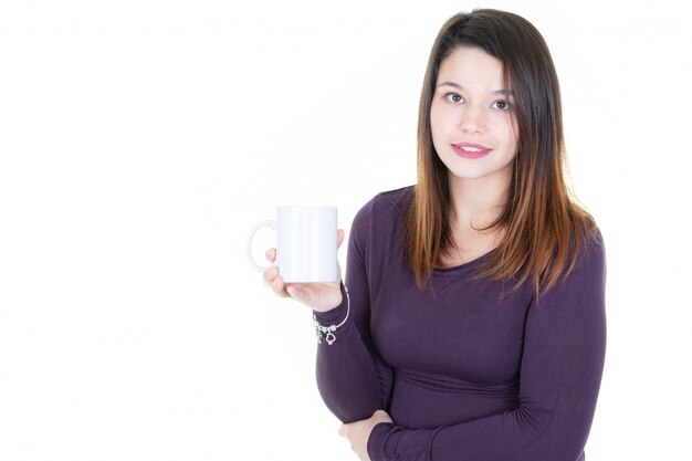 Joven caucásica bebiendo café o té sonriendo a la cámara con espacio en blanco copia en blanco