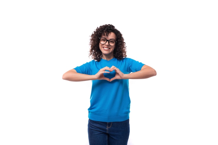 Foto una joven caucásica bien cuidada y sonriente con rizos está vestida con una camiseta azul