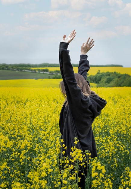 Joven caucásica en campo de colza amarillo