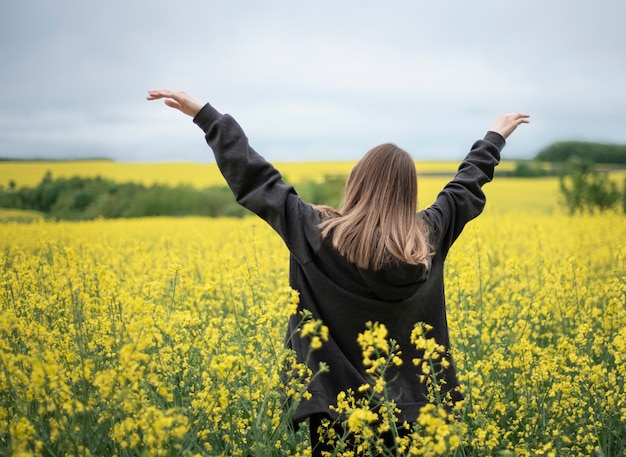 Joven caucásica en campo de colza amarillo