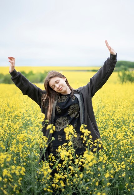 Joven caucásica en campo de colza amarillo