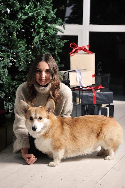 Foto una joven caucásica europea está sentada bajo un árbol de navidad