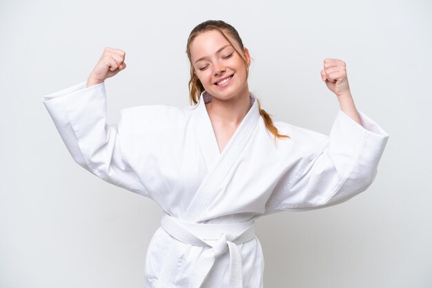 Joven caucásica haciendo karate aislada de fondo blanco haciendo un gesto fuerte