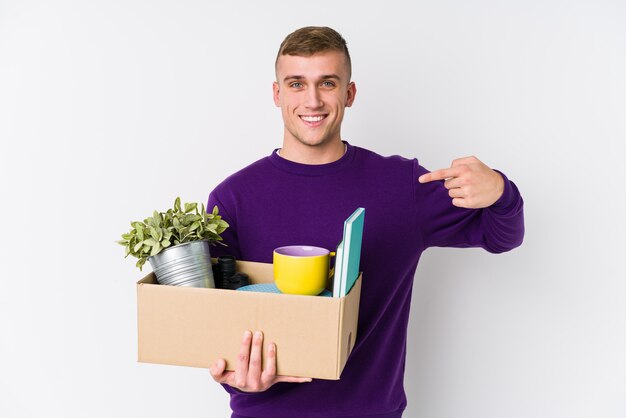 Joven caucásica mudarse a una nueva persona en casa señalando con la mano a una camisa copia espacio, orgulloso y confiado