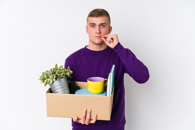 Joven caucásica mudarse a un nuevo hogar con los dedos en los labios manteniendo un secreto.