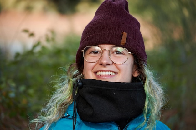 Joven caucásica sonriente con ropa de abrigo en la naturaleza en España