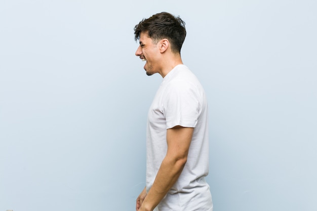 Joven caucásica vistiendo una camiseta blanca gritando hacia un espacio de copia