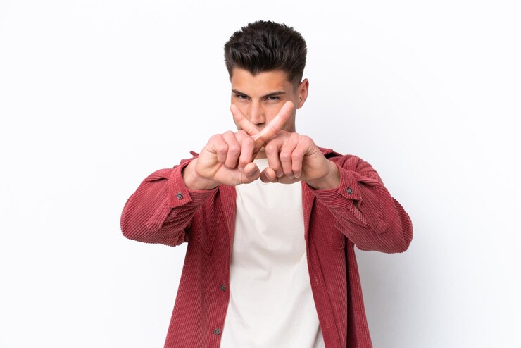 Foto joven caucásico aislado de fondo blanco haciendo un gesto de parada con la mano para detener un acto