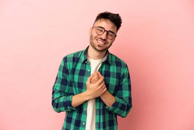 Joven caucásico aislado sobre fondo rosa riendo