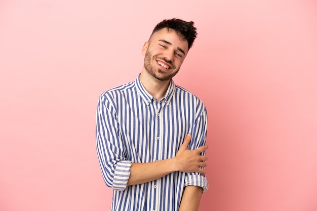 Joven caucásico aislado sobre fondo rosa riendo