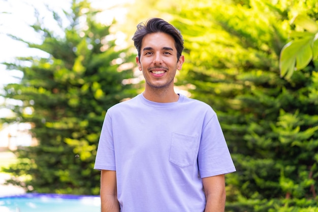 Joven caucásico al aire libre con expresión feliz