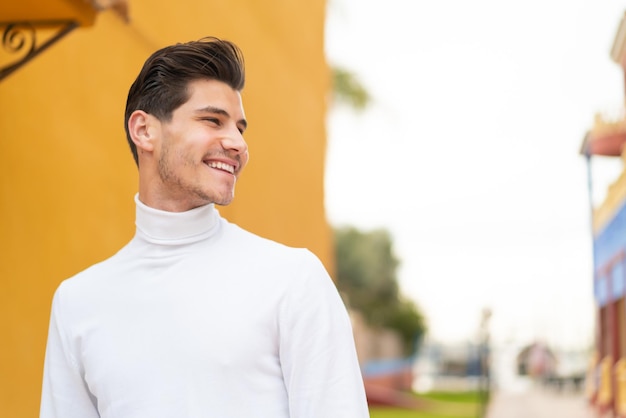 Joven caucásico al aire libre con expresión feliz