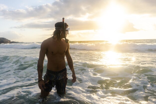 Joven caucásico buceando en el mar en busca de especies marinas