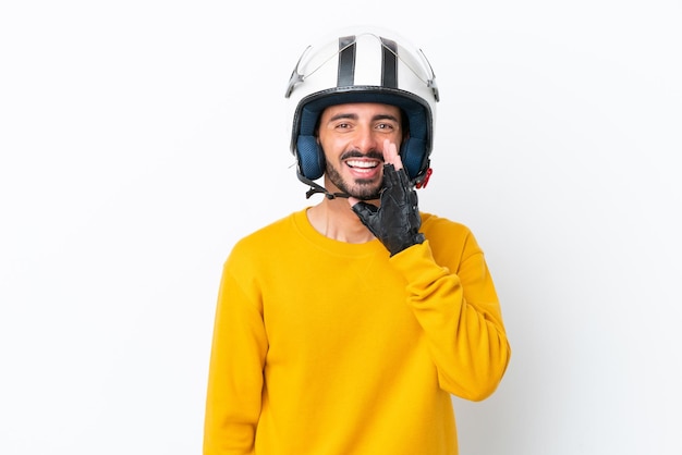 Joven caucásico con casco de motocicleta aislado de fondo blanco gritando con la boca abierta