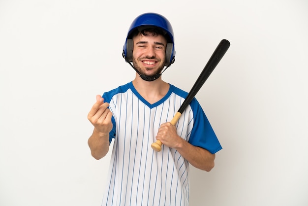 Joven caucásico jugando béisbol aislado sobre fondo blanco haciendo gesto de dinero