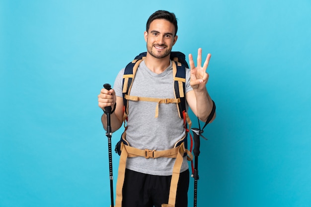 Joven caucásico con mochila y bastones de trekking