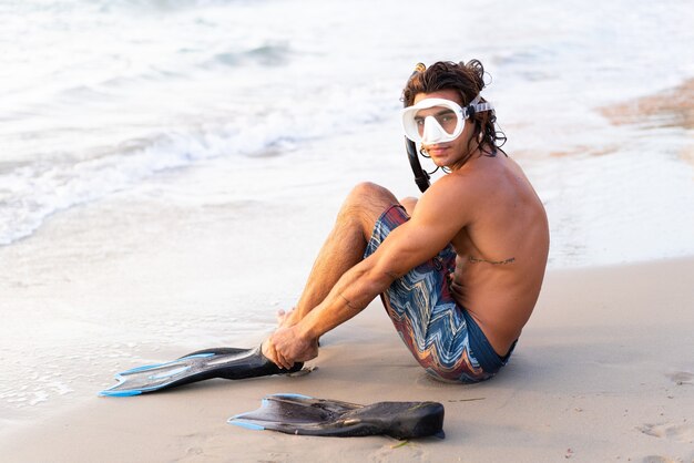 Joven caucásico preparándose para sumergirse en el mar