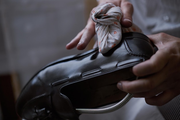 Joven caucásico reparando viejos zapatos de cuero masculinos.