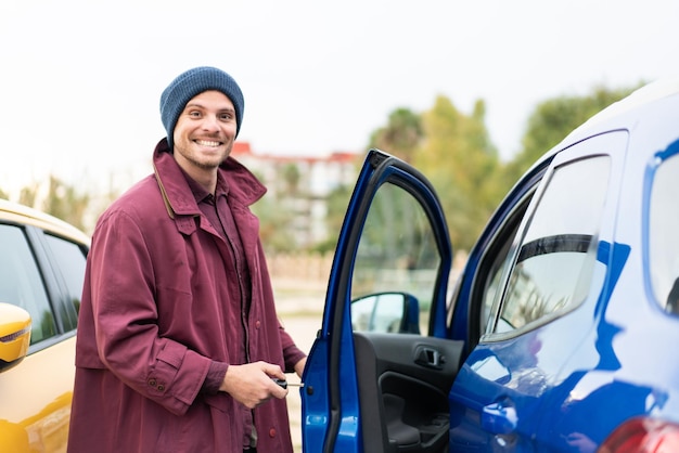 Joven caucásico sosteniendo las llaves del auto al aire libre