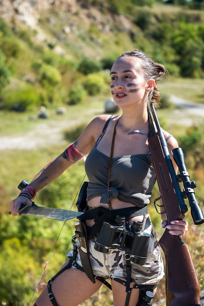 Joven cazador en la parte superior con un rifle, en verano en la naturaleza. tirador